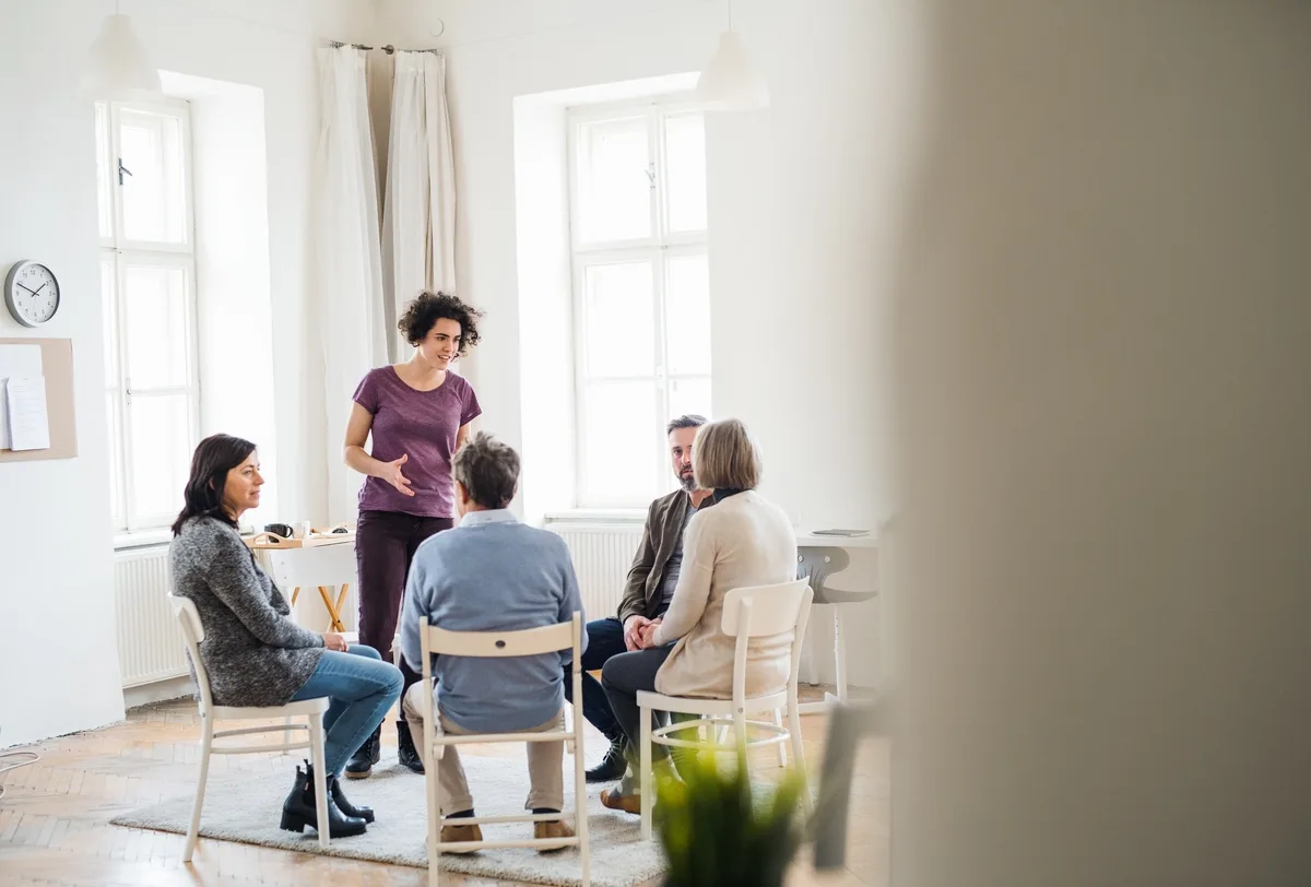 Group Therapy: Woman standing speaking to a group