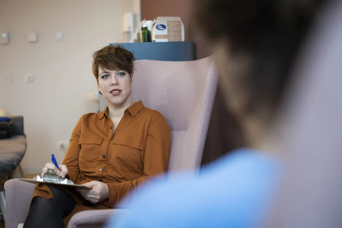 Case Management: Case manager smiling and listening to patient with clipboard