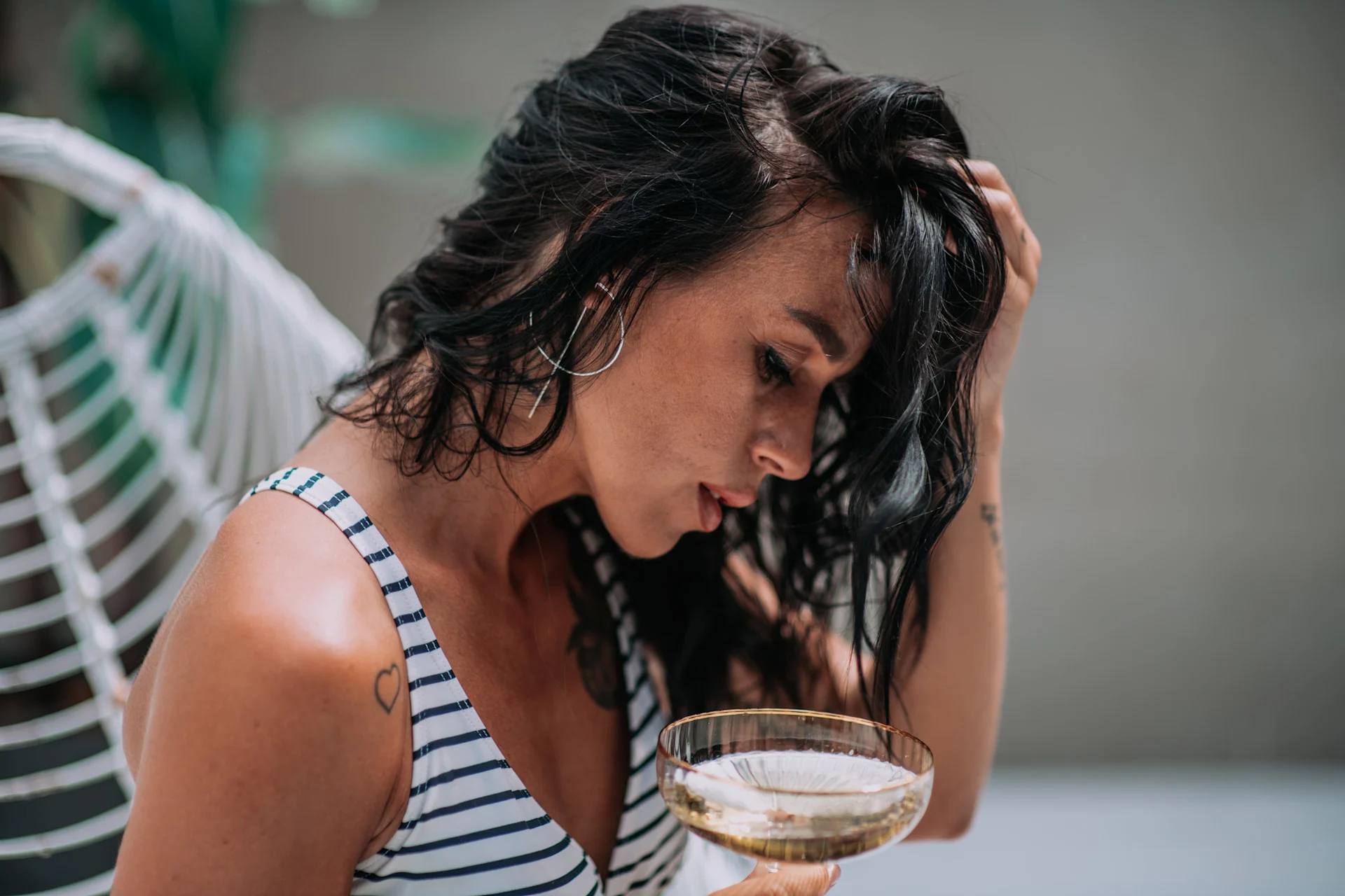 Woman reflecting with a drink, showing early signs of alcoholism.