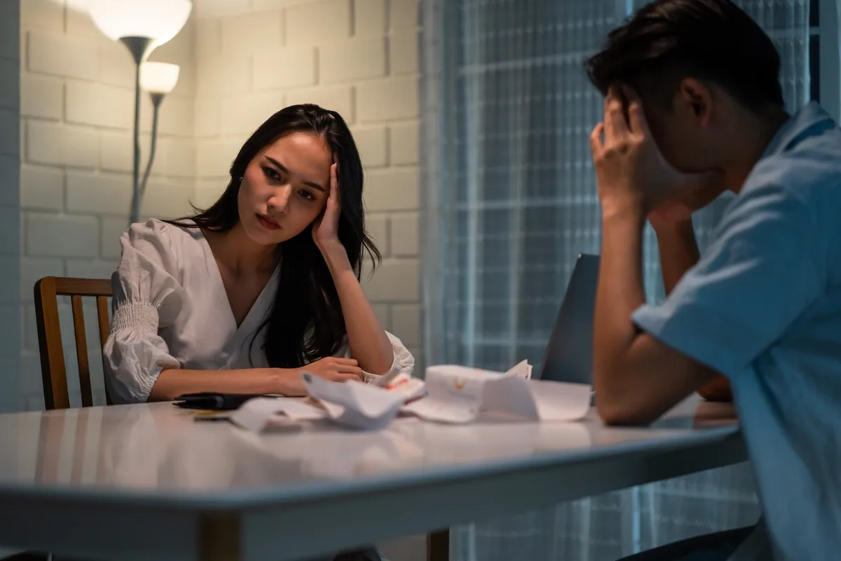 Gambling Addiction: Depressed couple looking at bills