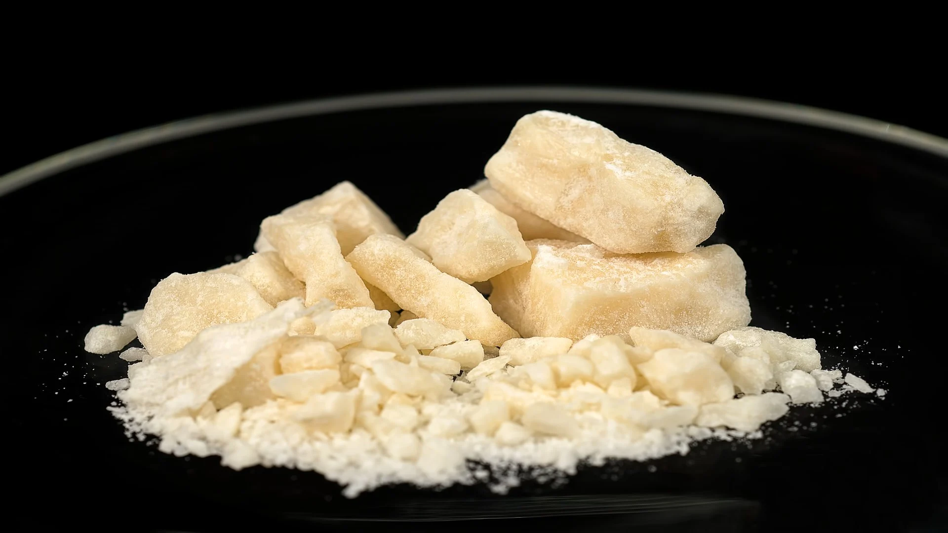 Close-up of crack cocaine in rock form on a black plate, illustrating the appearance and form of the drug when answering ‘what is crack?’