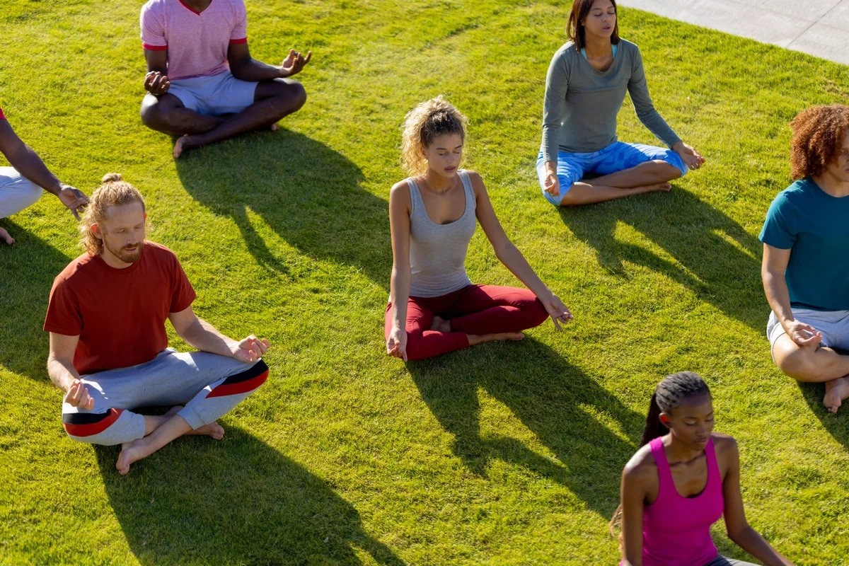 Experiential Therapy: Men & women doing yoga in the park Experiential Therapy: Men & women doing yoga in the park