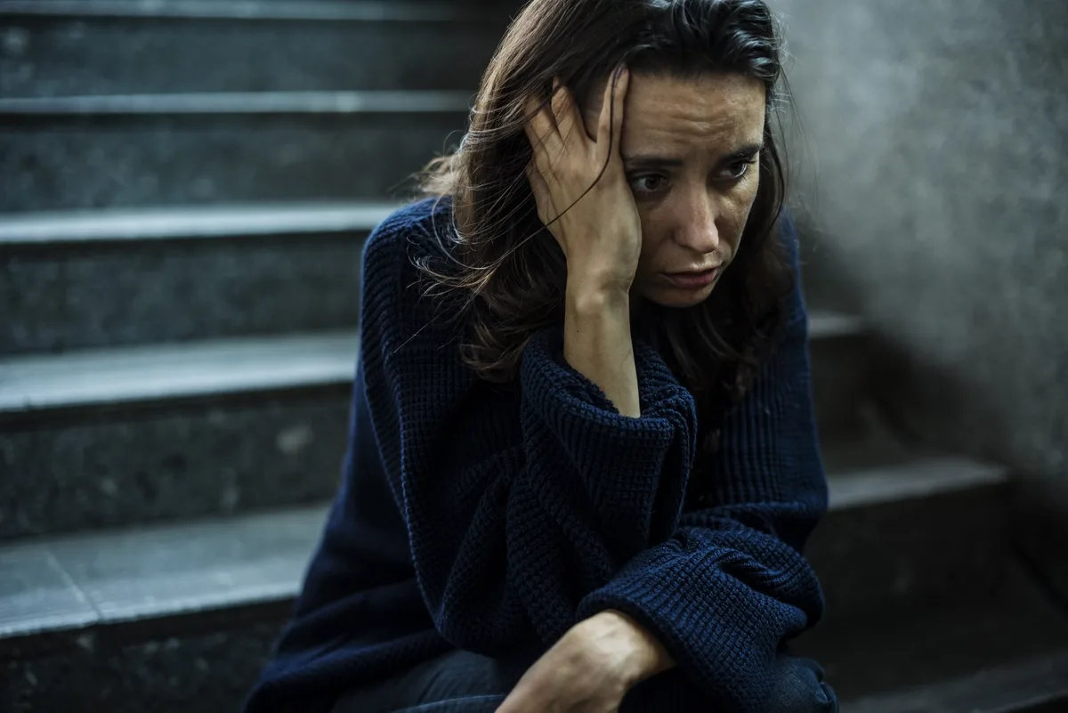 Fentanyl Addiction: Woman sitting in a stairway
