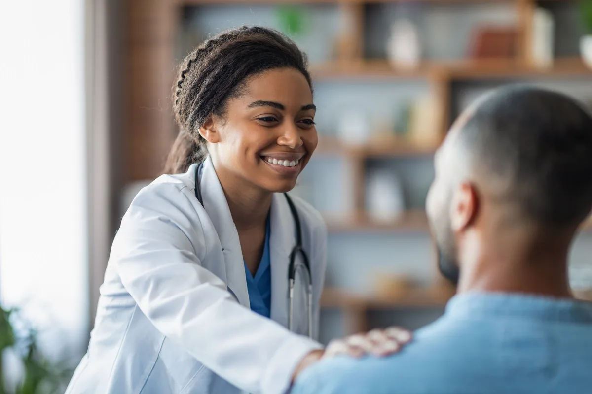 Trauma Informed Therapy: Doctor comforting patient with hand on his shoulder