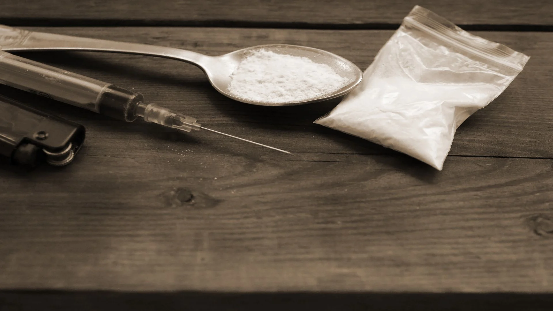 Syringe, lighter, and a spoon full of speed with a little ziplock bag of amphetamine prepared by a substance user.