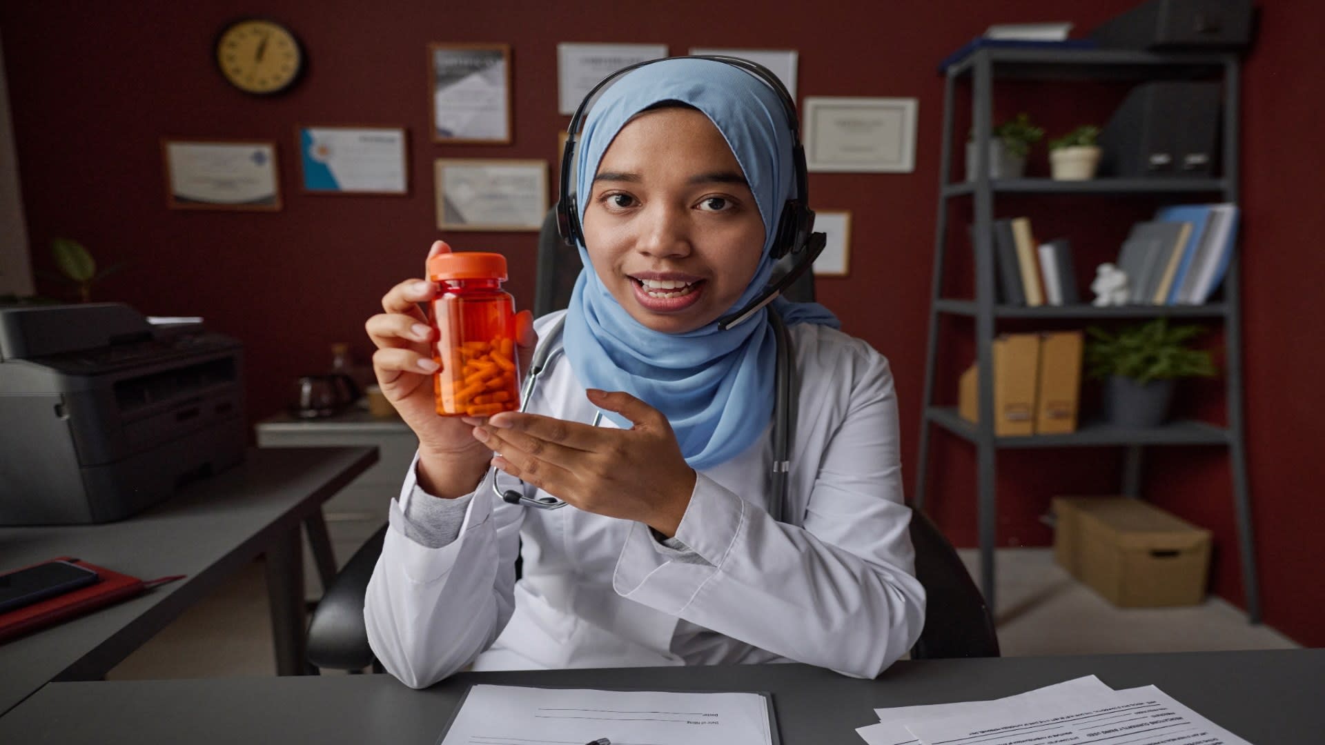 female-doctor-in-hijab-demonstrating-bottle-of-pil-2025-02-11-18-52-58-utc