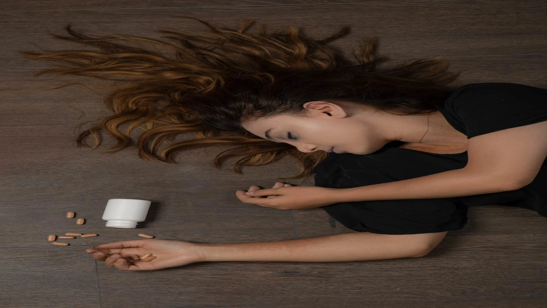 young girl on the floor suffering from a barbiturate overdose.