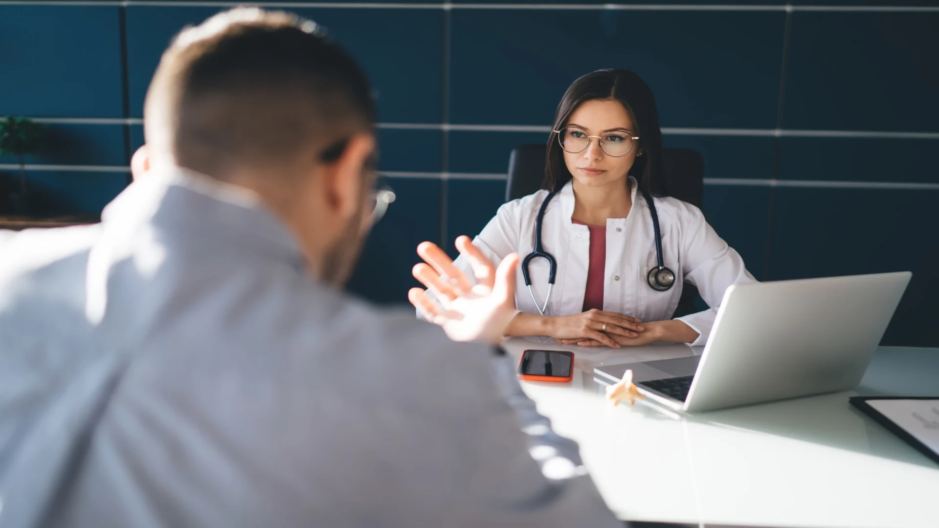 female-doctor-sitting-and-looking-at-male-patient-2025-03-24-20-38-34-utc