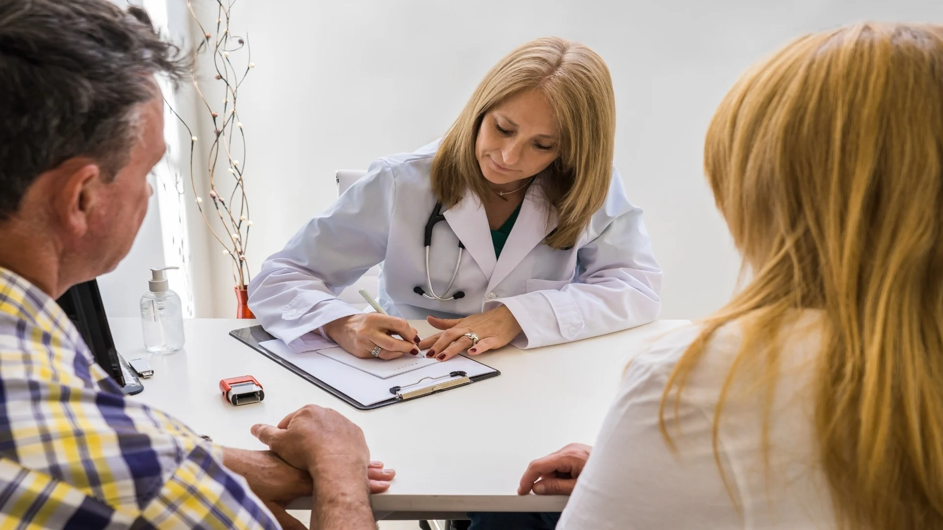 female-doctor-writing-prescription-to-a-couple-2025-03-11-18-48-58-utc (1)