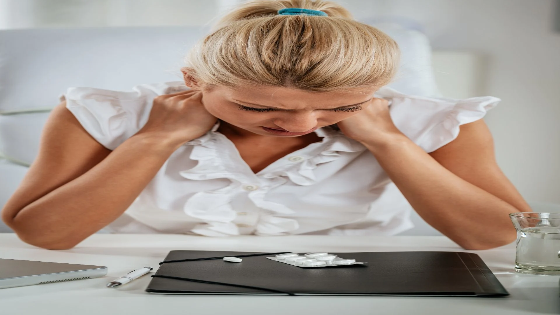 Woman needing Naltrexone to deal with her withdrawal effects, holding her aching shoulders.