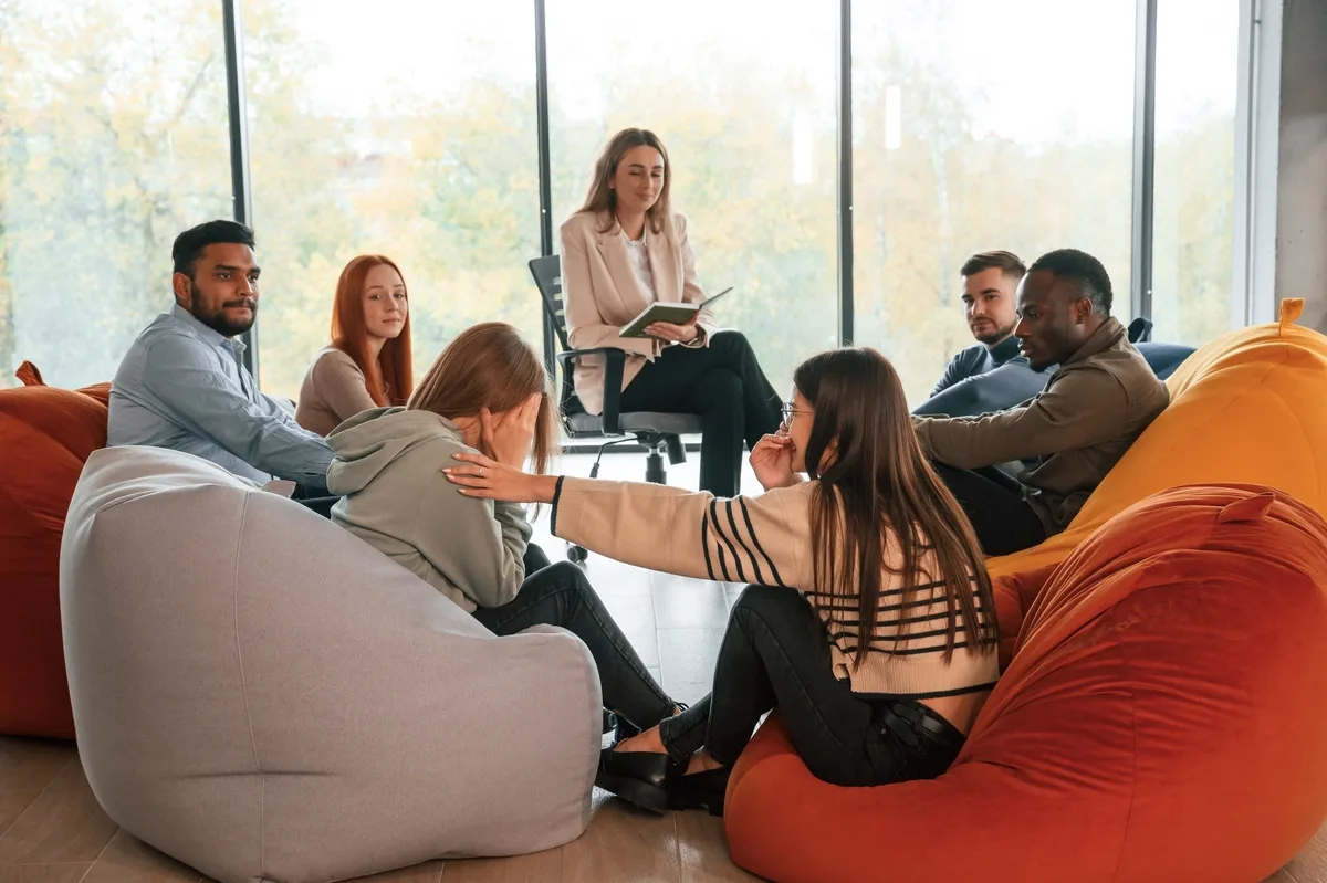 Group Therapy: Group consoling woman during group therapy