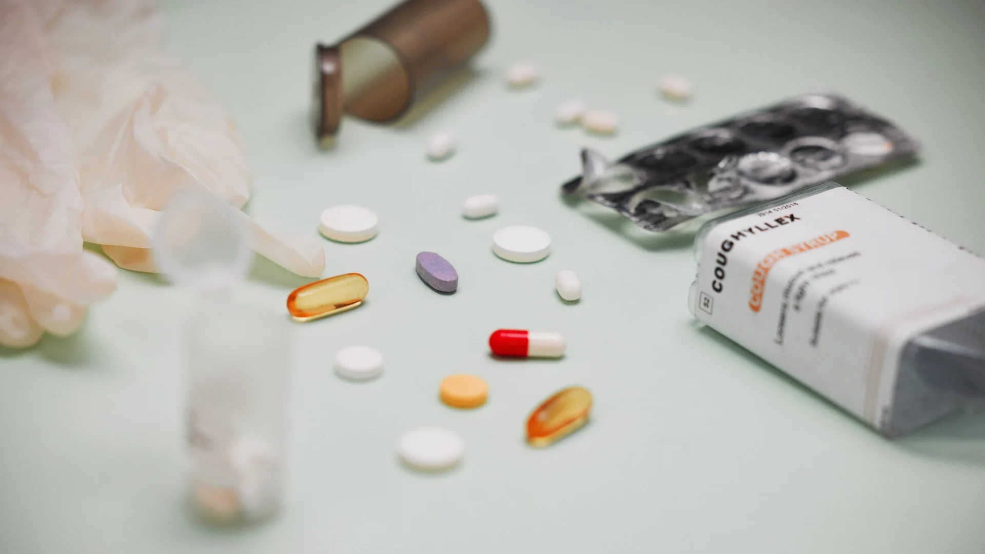 Variety of pills scattered across a table, portraying medication misuse or side effects from high Vyvanse dosage.