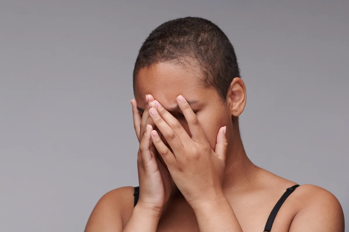 Sex Addiction: Woman shamefully holding her hands over her face