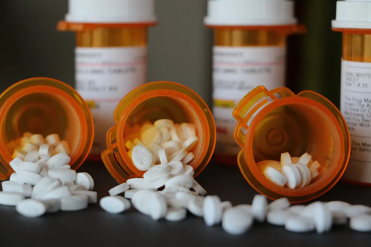 Opioid Addiction: Close up of pills spilling out of pill bottles