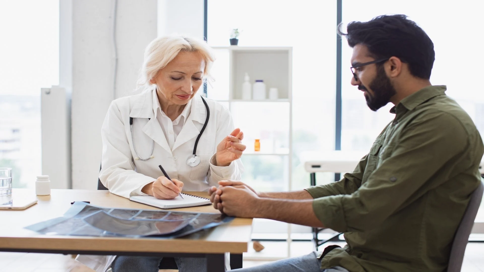 gentleman-describing-symptoms-of-illness-to-senior-2024-12-13-12-20-54-utc