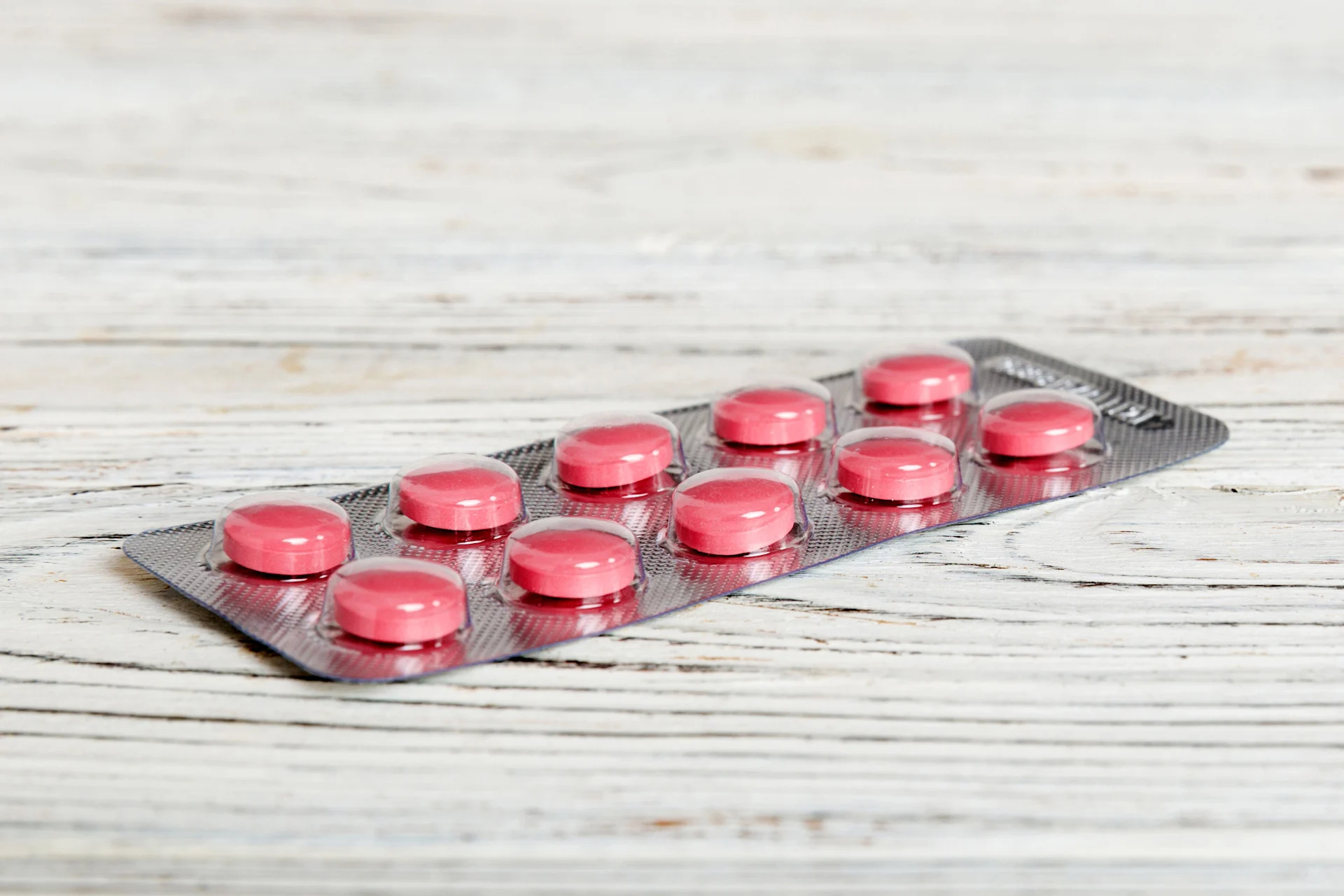 Benadryl capsules on a table, highlighting the risk of mixing alcohol and antihistamines.