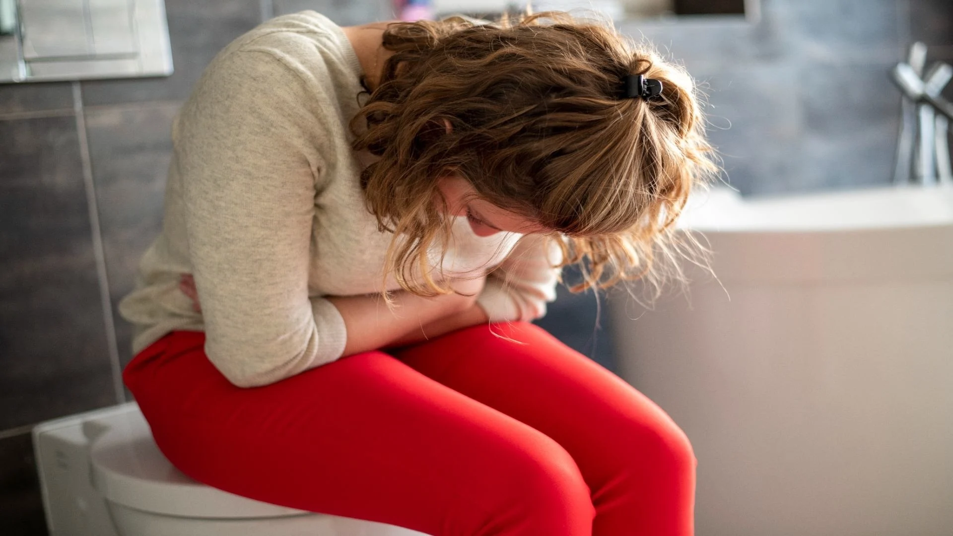 woman-sitting-on-the-toilet-with-a-head-ache-and-c-2025-04-03-21-49-13-utc