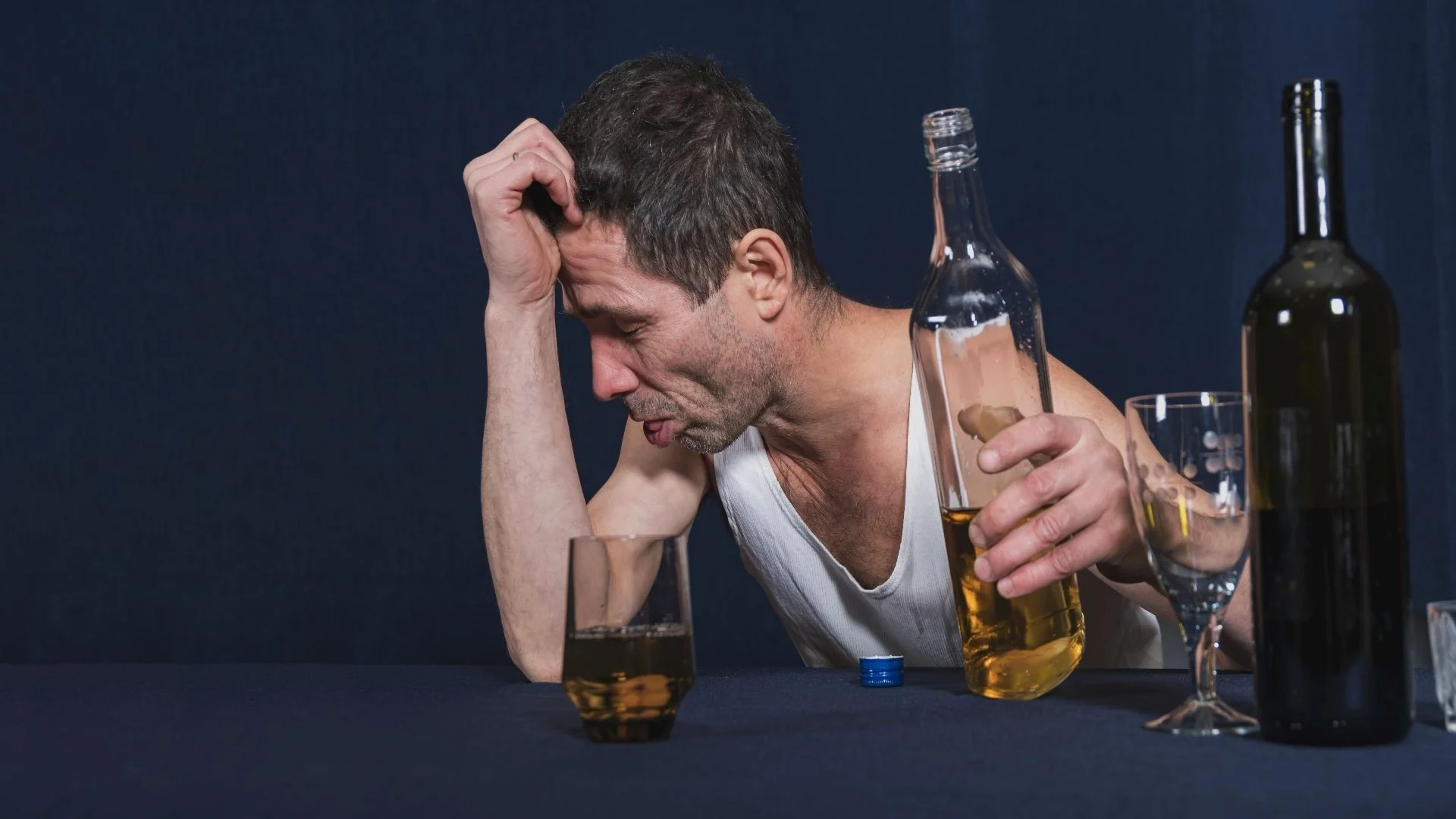 drunken-lonely-man-sits-at-table-and-holds-his-hea-2025-02-02-13-14-46-utc