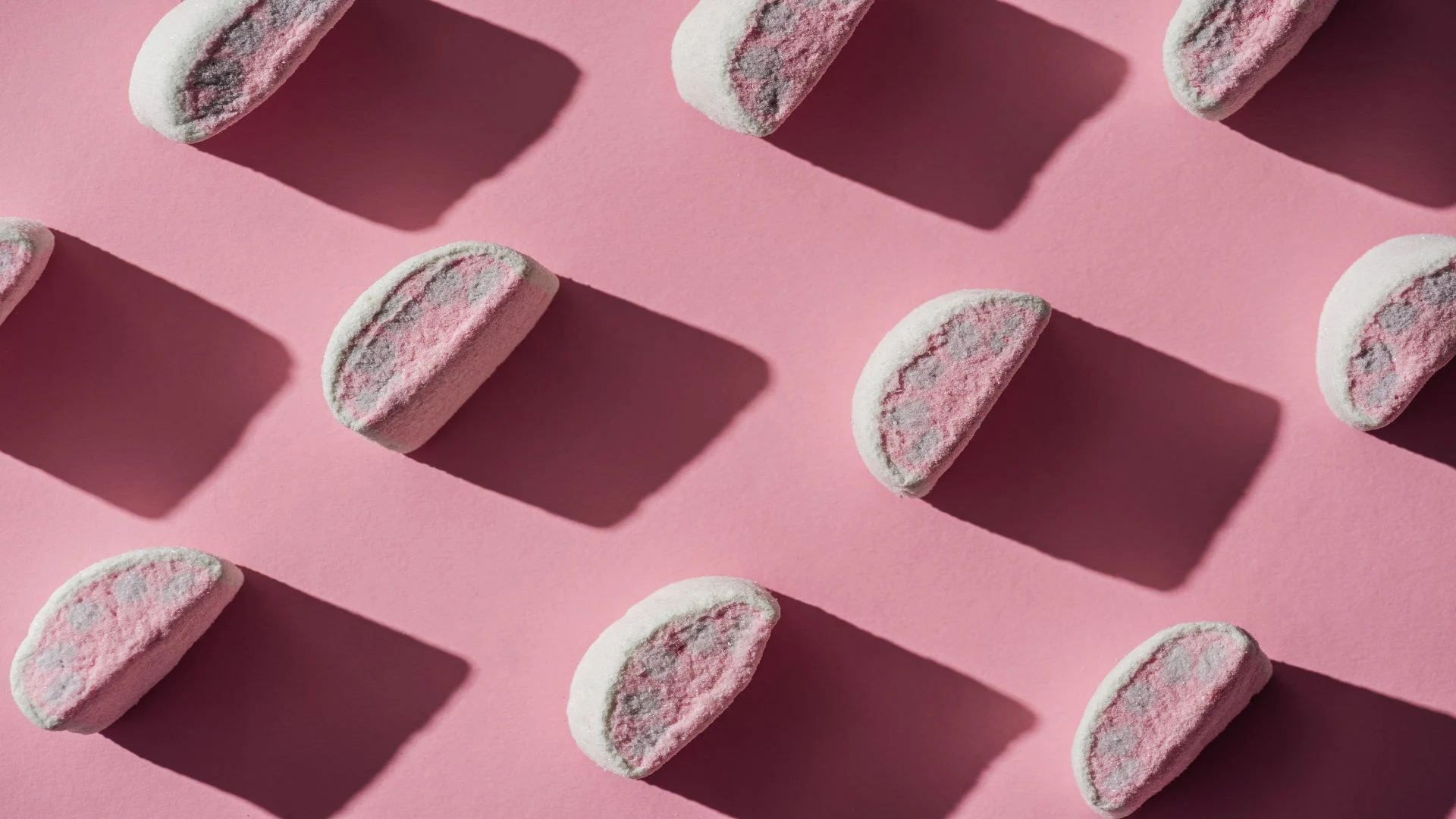 Pink pill aesthetic portrayed through mochi-style candies mimicking the look of pharmaceutical tablets.