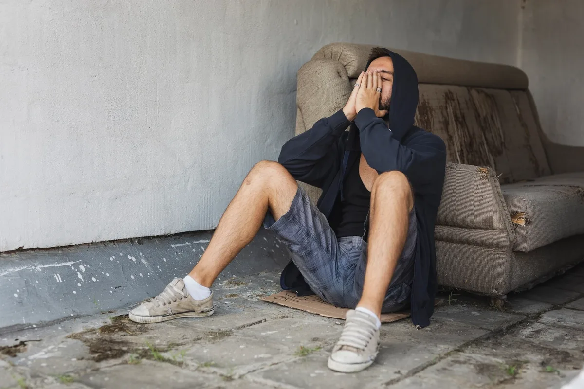 Inhalant Addiction: Man kneeling on the ground by the couch