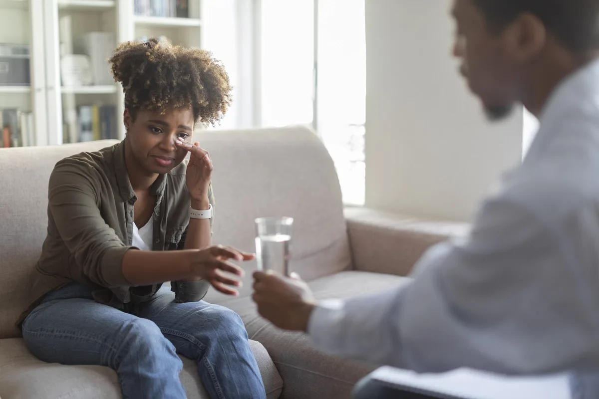 Motivational Interviewing: Woman emotionally reaching for a glass of water