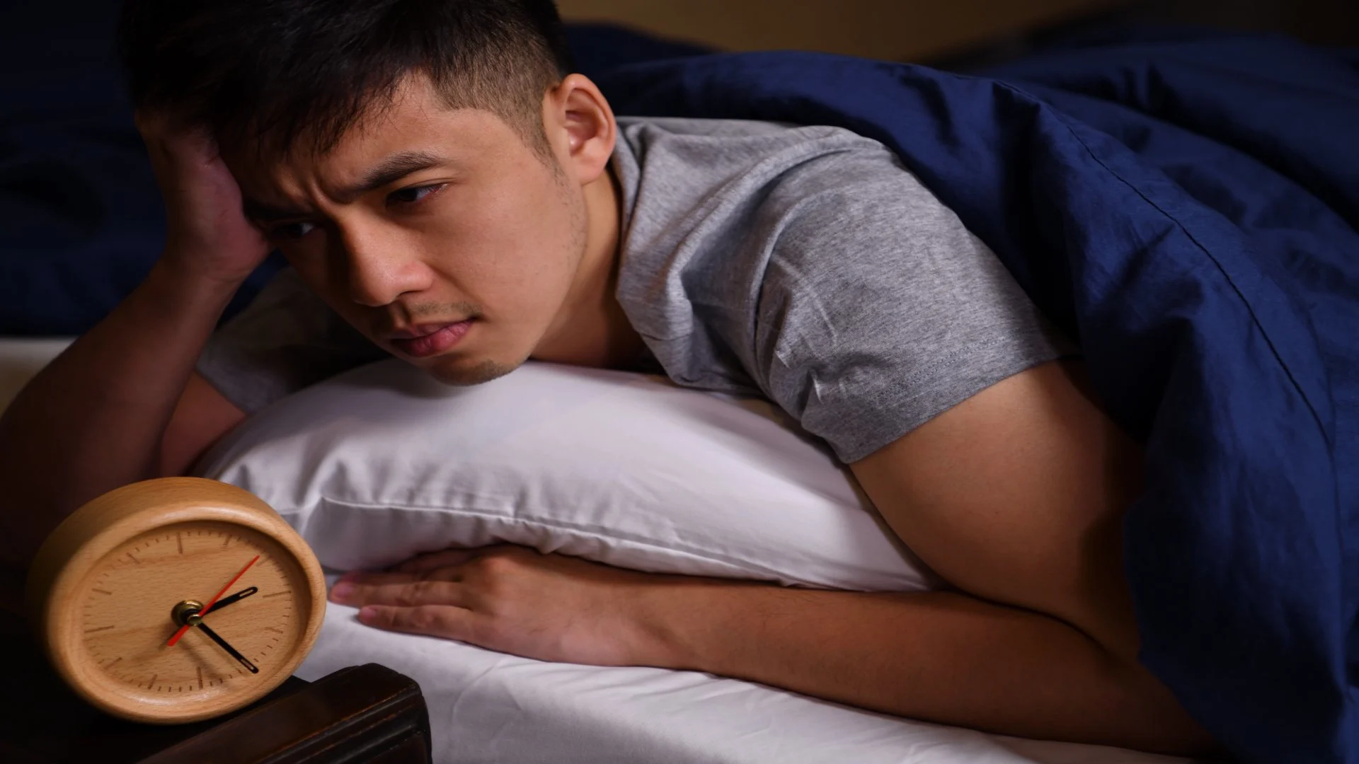 man suffering from insomnia laying in bed can't sleep thinking about zolpidem