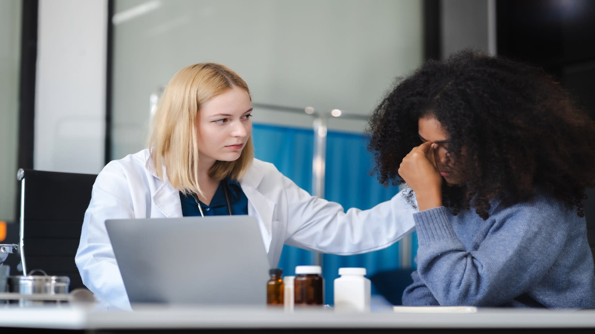 A healthcare provider gently consoles a tearful woman during a clinical consultation, illustrating emotional support as a key part of helping someone with depression.