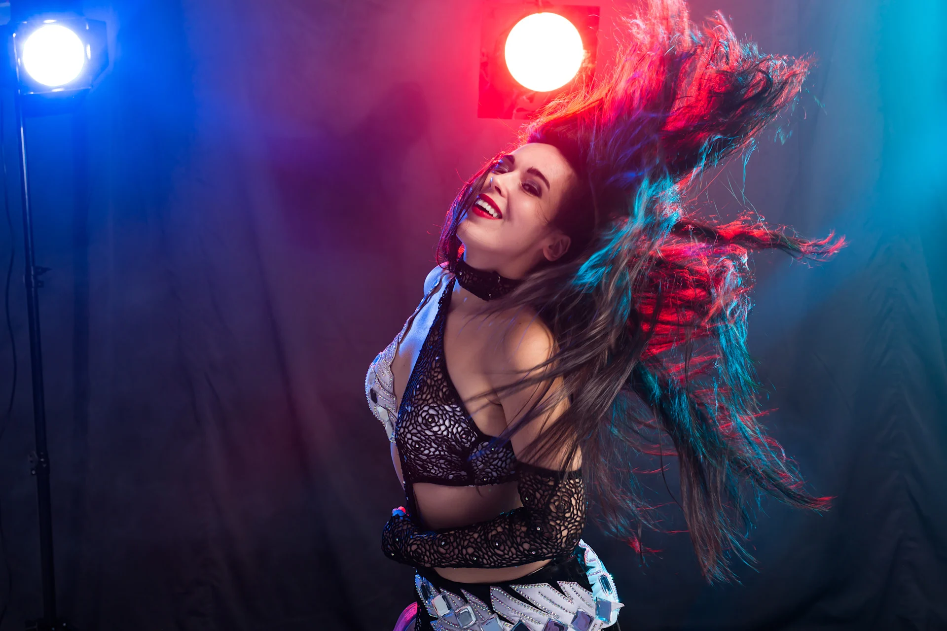 How long does molly last party scene, showing a smiling young woman dancing under bright red and blue club lights, suggesting the energetic, euphoric effects of MDMA.