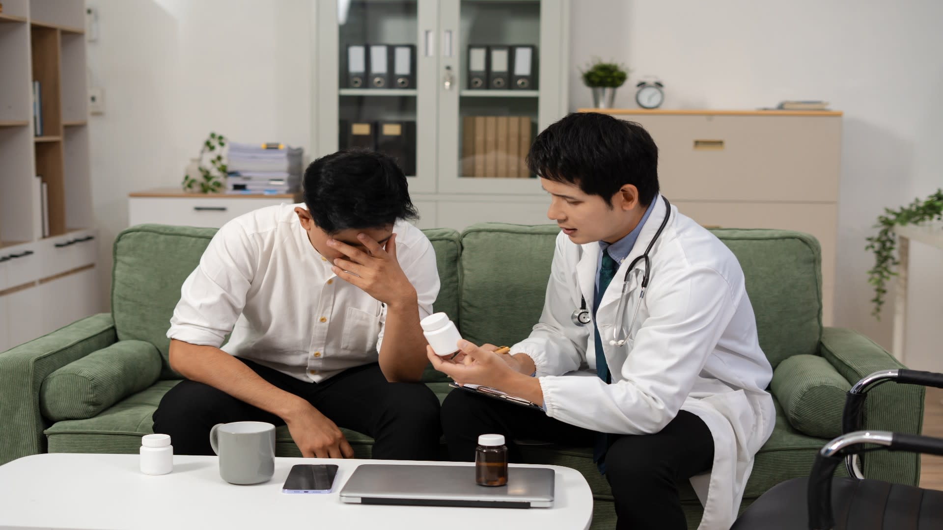 A doctor calmly discusses a prescription bottle with a patient showing signs of distress, illustrating the medical side of panic attack treatment options, including pharmacological support.