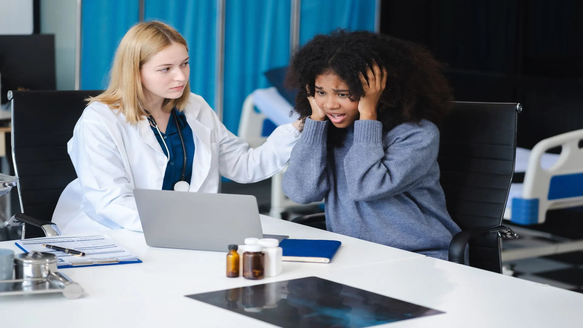A female doctor gently consoles a young woman in emotional distress during a medical consultation—representing the emotional and mental toll some individuals experience from oxycodone side effects.