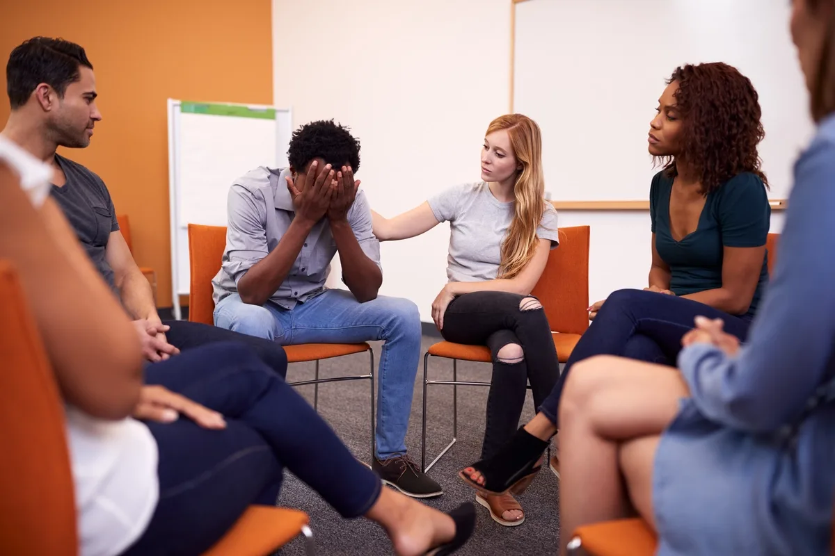 TMS: Group of friends comforting distraught man