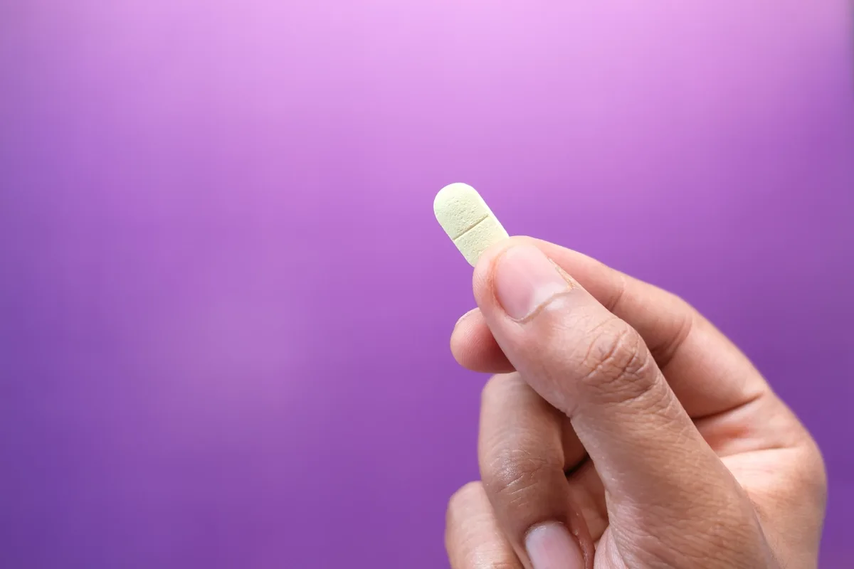 Stimulant Addiction: Close up of a hand holding a pill Stimulant Addiction: Close up of a hand holding a pill