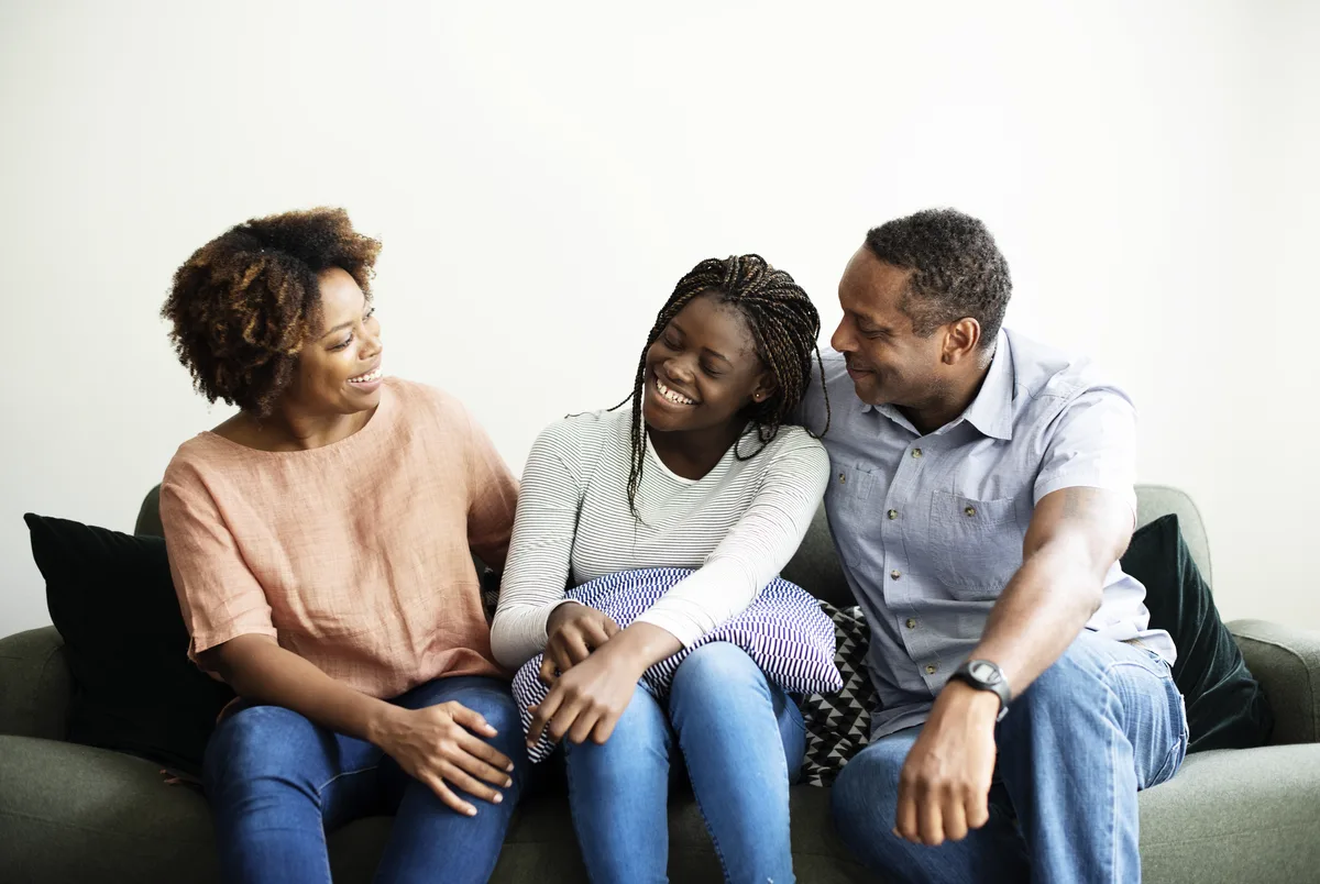 Family Counseling: Family happily sitting on the couch Family Counseling: Family happily sitting on the couch