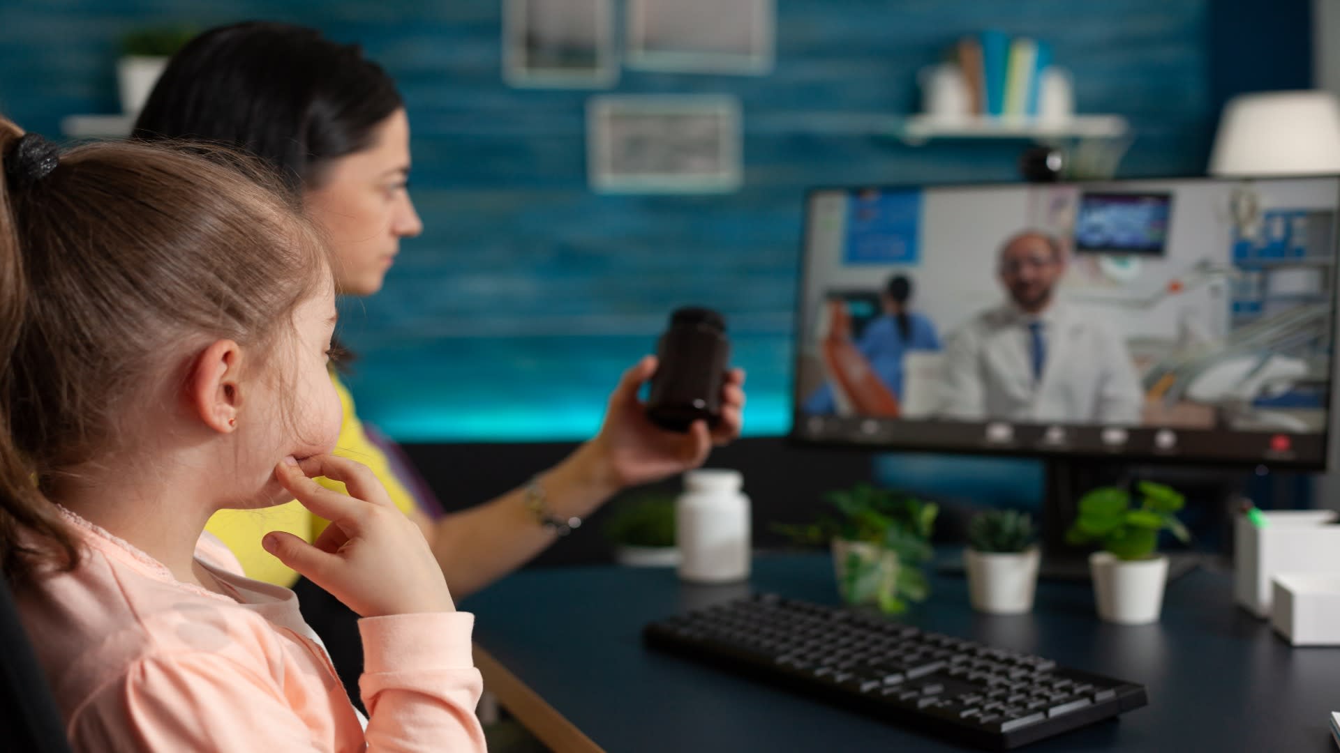 Mother and young daughter attending a telehealth session for behavioral health concerns, speaking with a pediatric provider via video call.