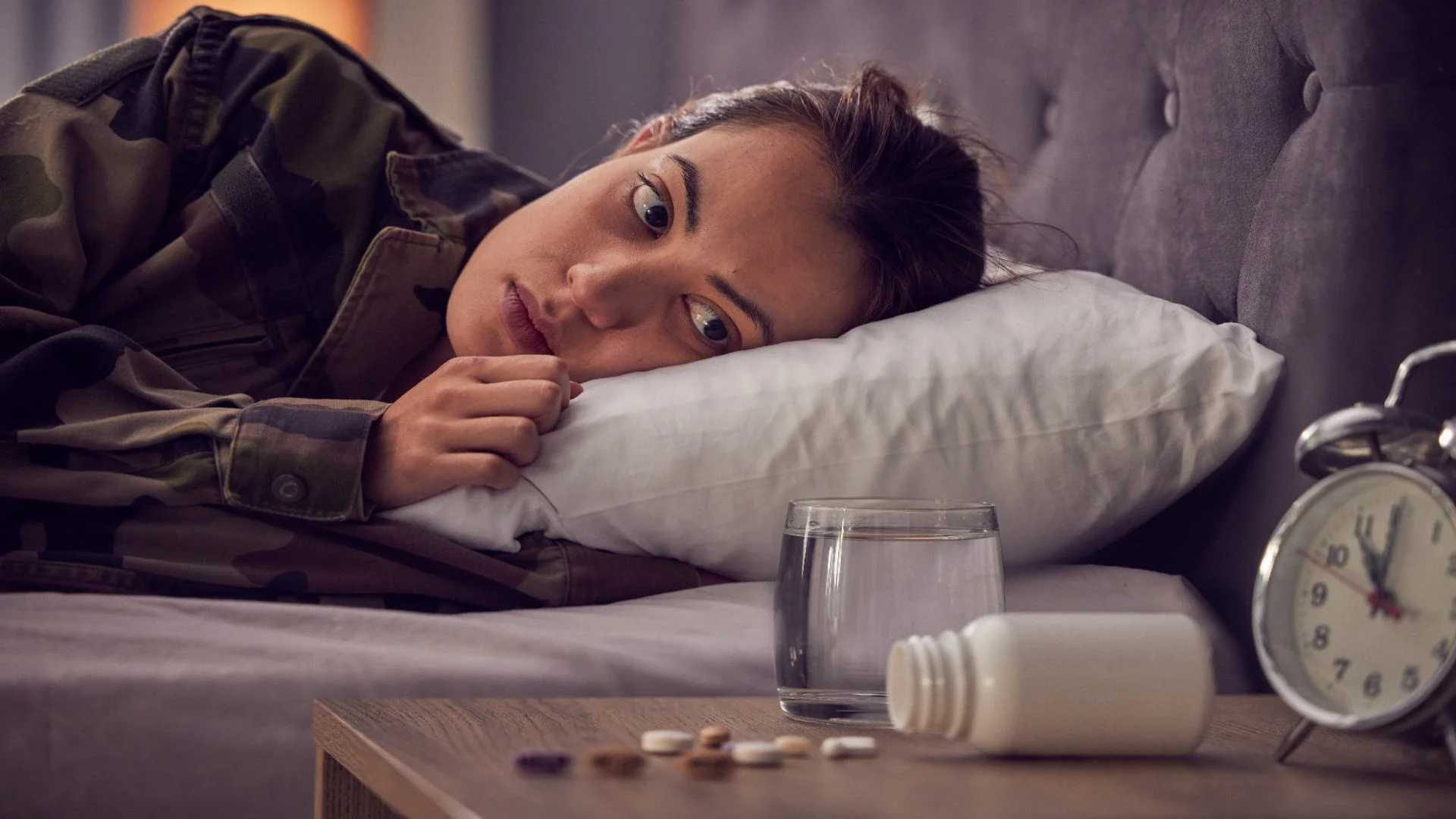 depressed woman in bed trying to sleep but ambien is not kicking in.