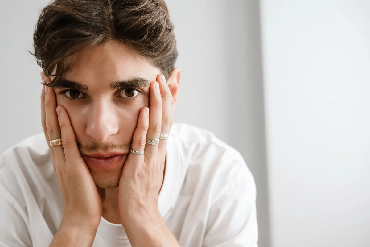 Man concerned with hands on his cheeks