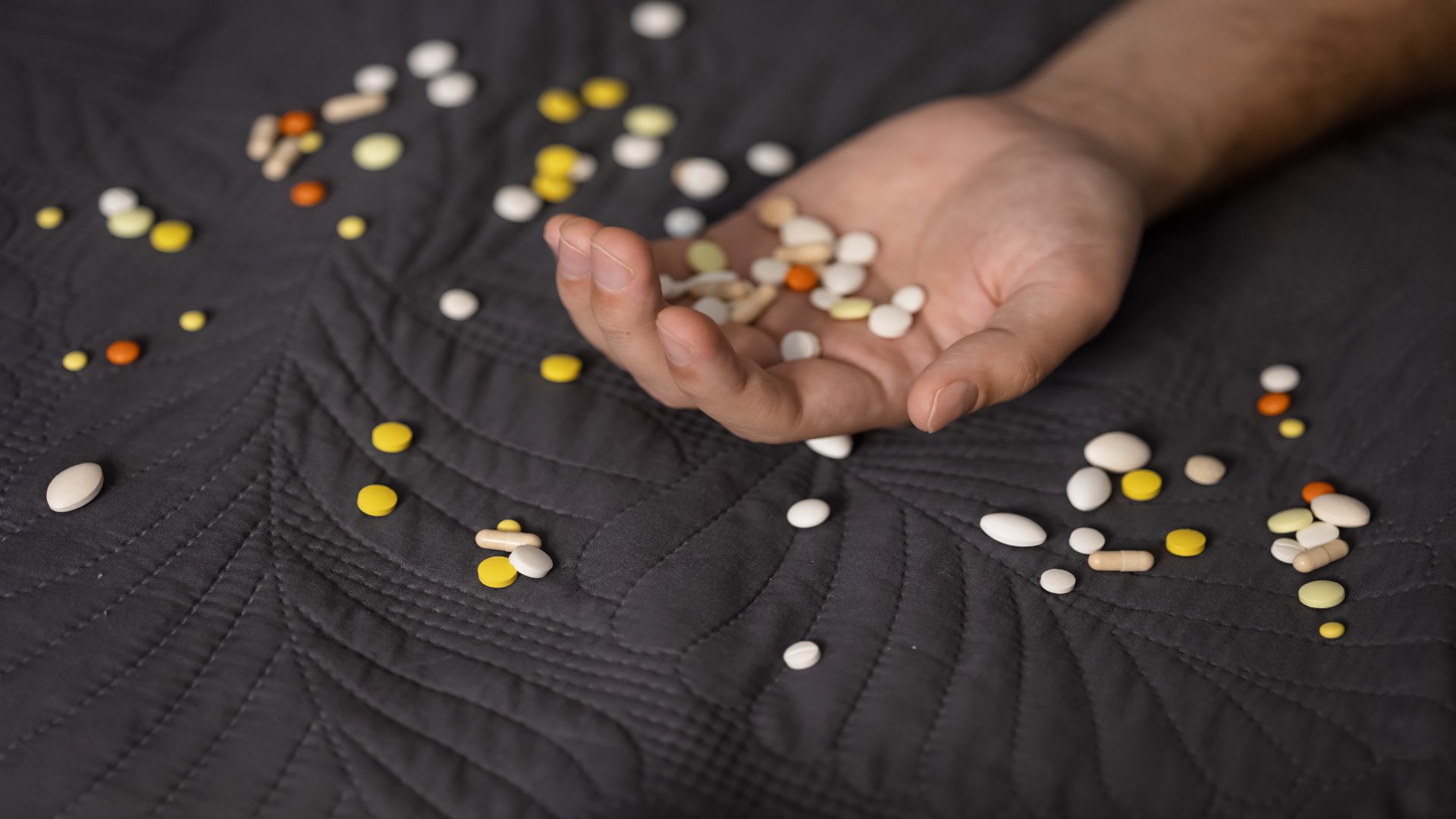 Close-up of a person holding a variety of tablets — raising awareness about prescription drug misuse and how medications like Valium may be taken improperly. Close-up of a person holding a variety of tablets — raising awareness about prescription drug misuse and how medications like Valium may be taken improperly.