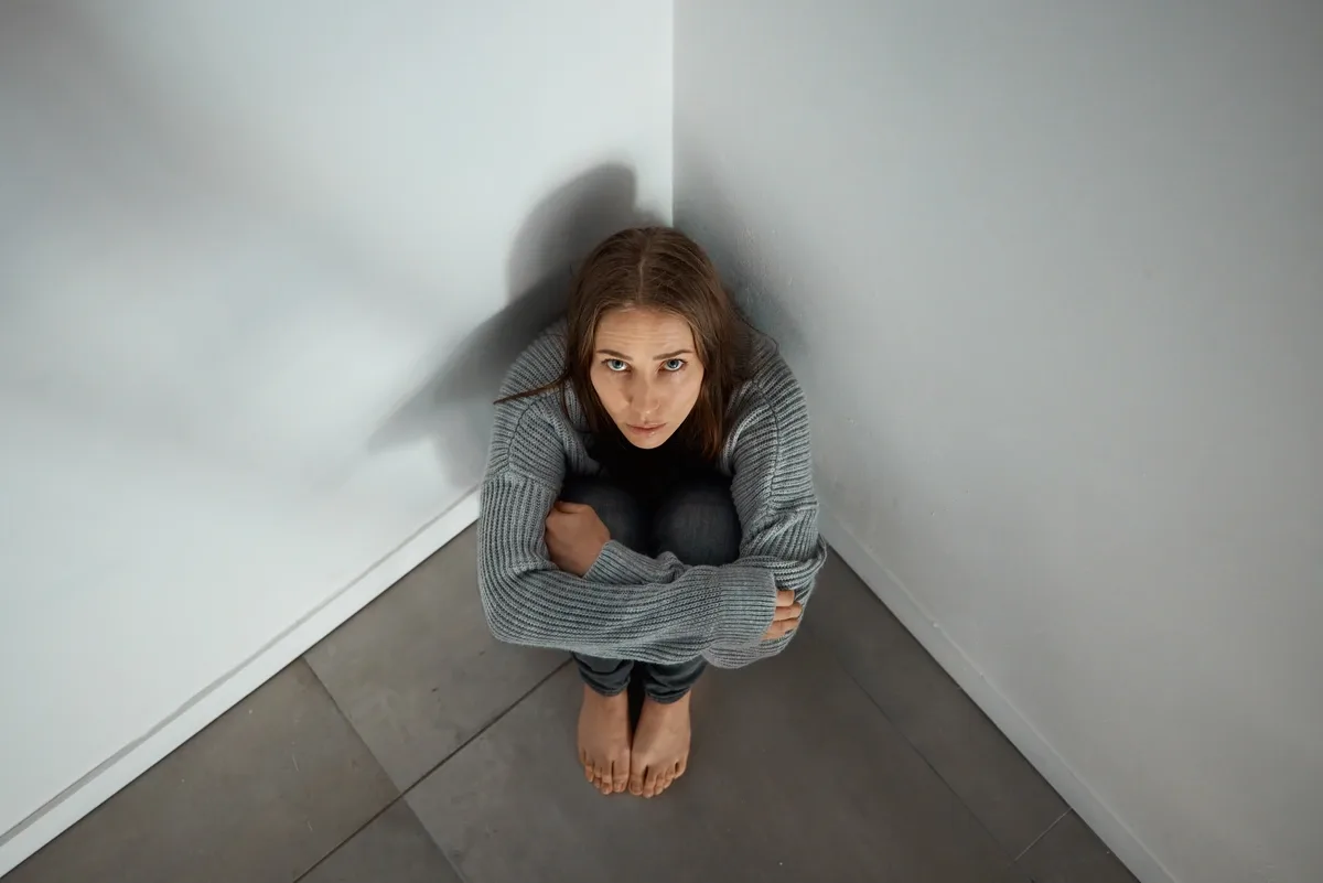 Paranoid Schizophrenia Patient Sitting on the Floor Looking up