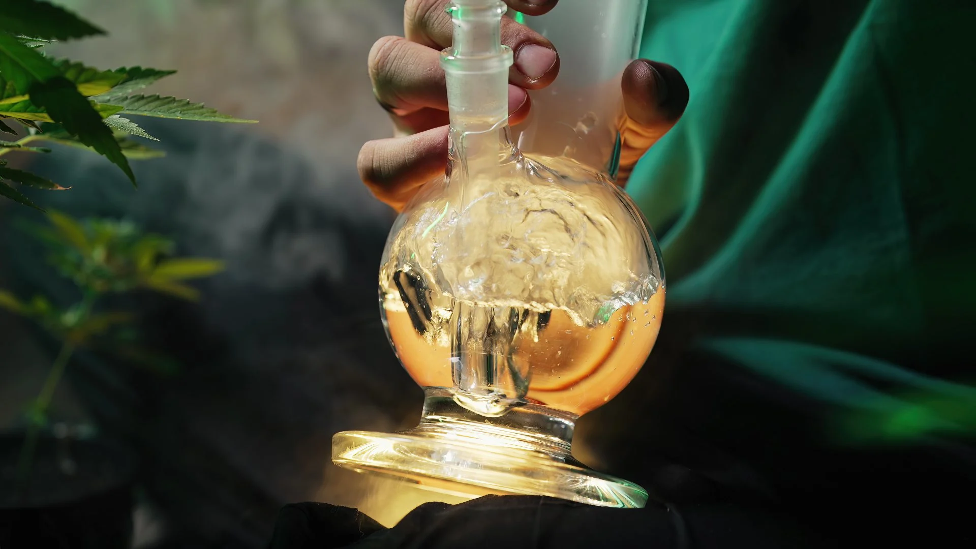 THC-O consumption method shown with a close-up of a person using a glass water bong for cannabis inhalation.