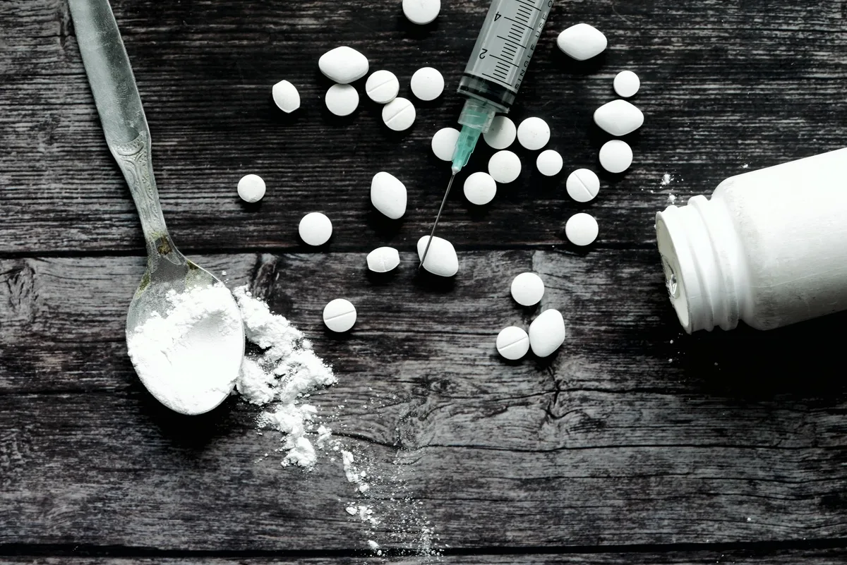 Fentanyl Addiction: Pills crushed up on a table with a syringe Fentanyl Addiction: Pills crushed up on a table with a syringe