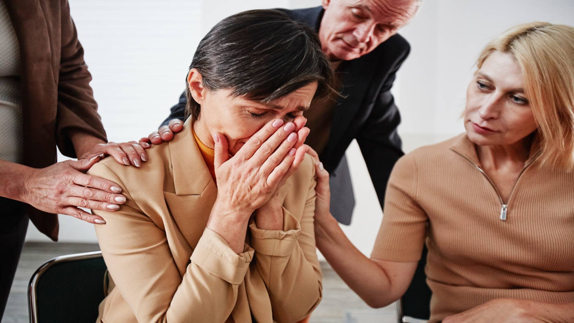 Synthetic opioid addiction support group helping a distressed woman during a recovery session.