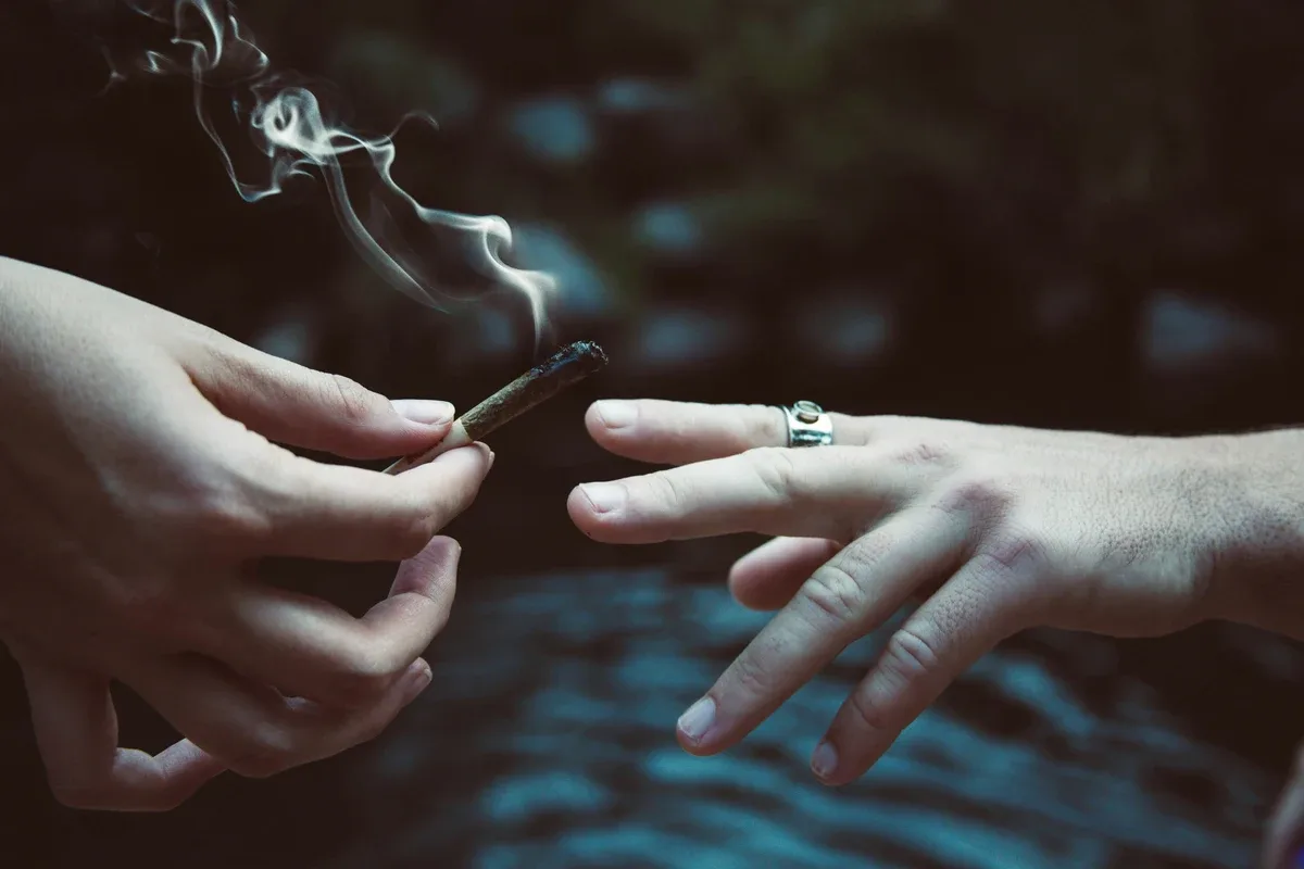 Marijuana Addiction: Close up of two people passing a joint