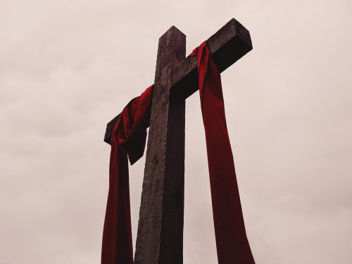 Christian cross with red ribbon hanging from it