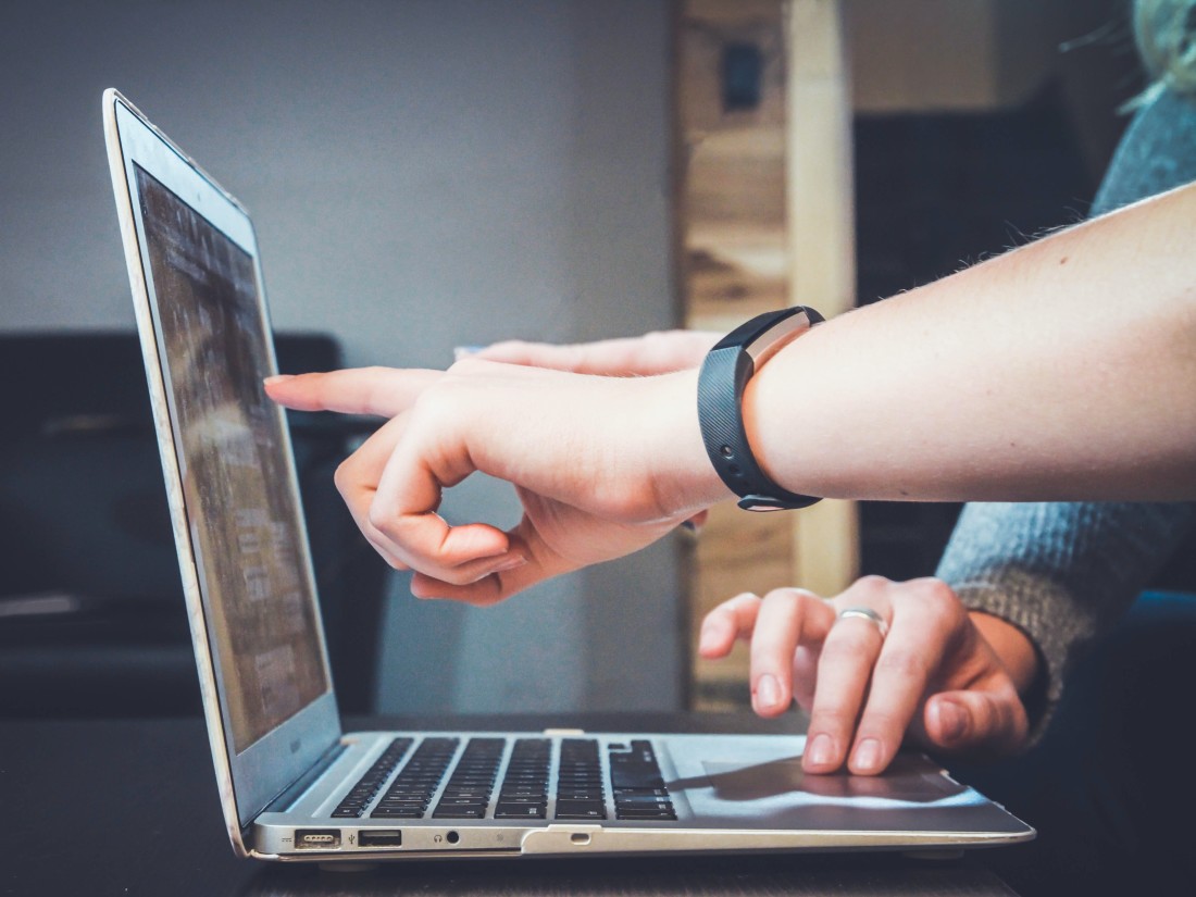 two people at a laptop discussing data variables