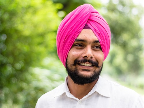A sikh person with a pink turban