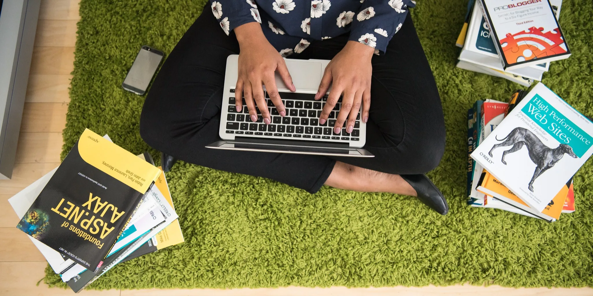 Woman at laptop surrounded by technical books