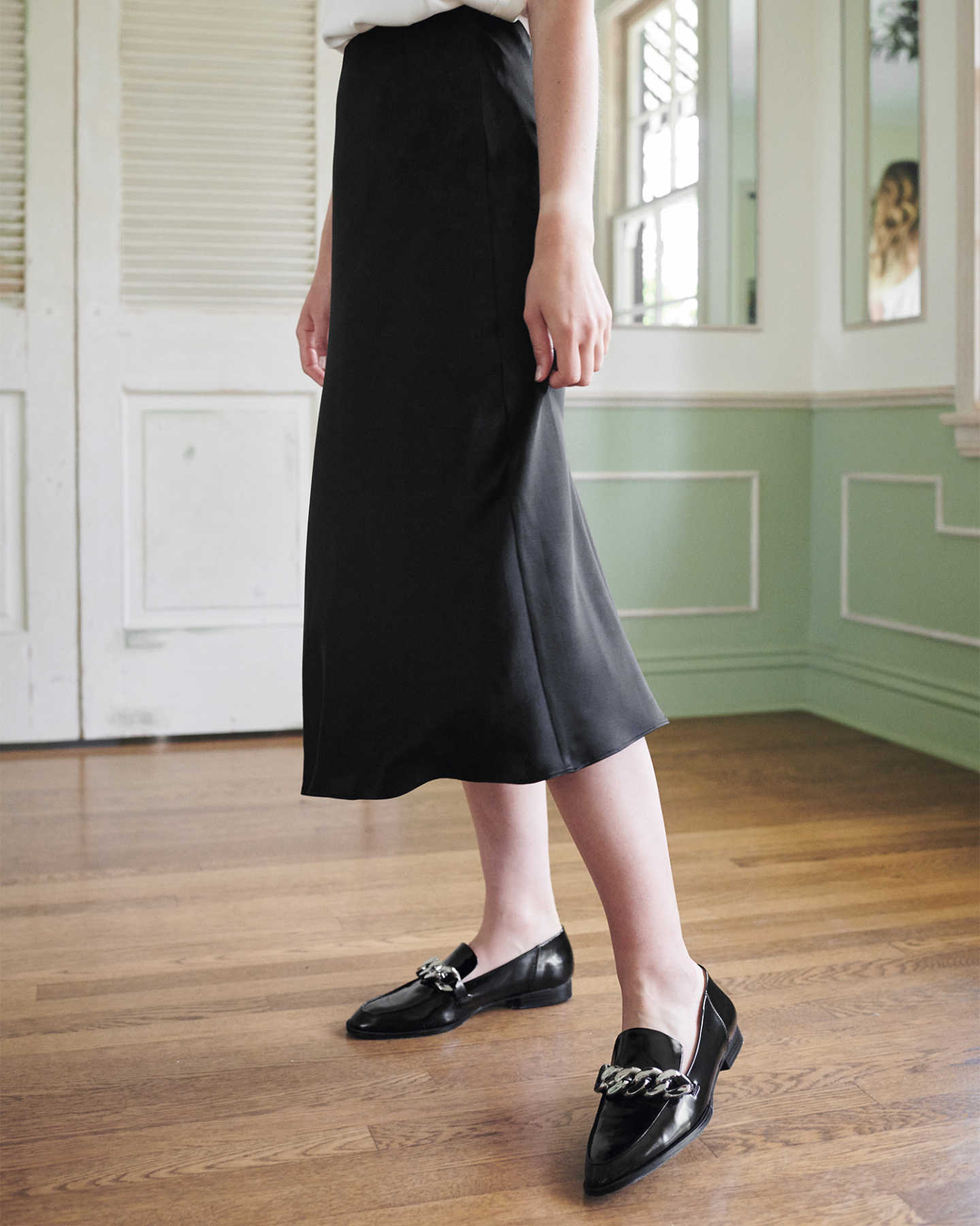 Woman wearing black silk skirt from side