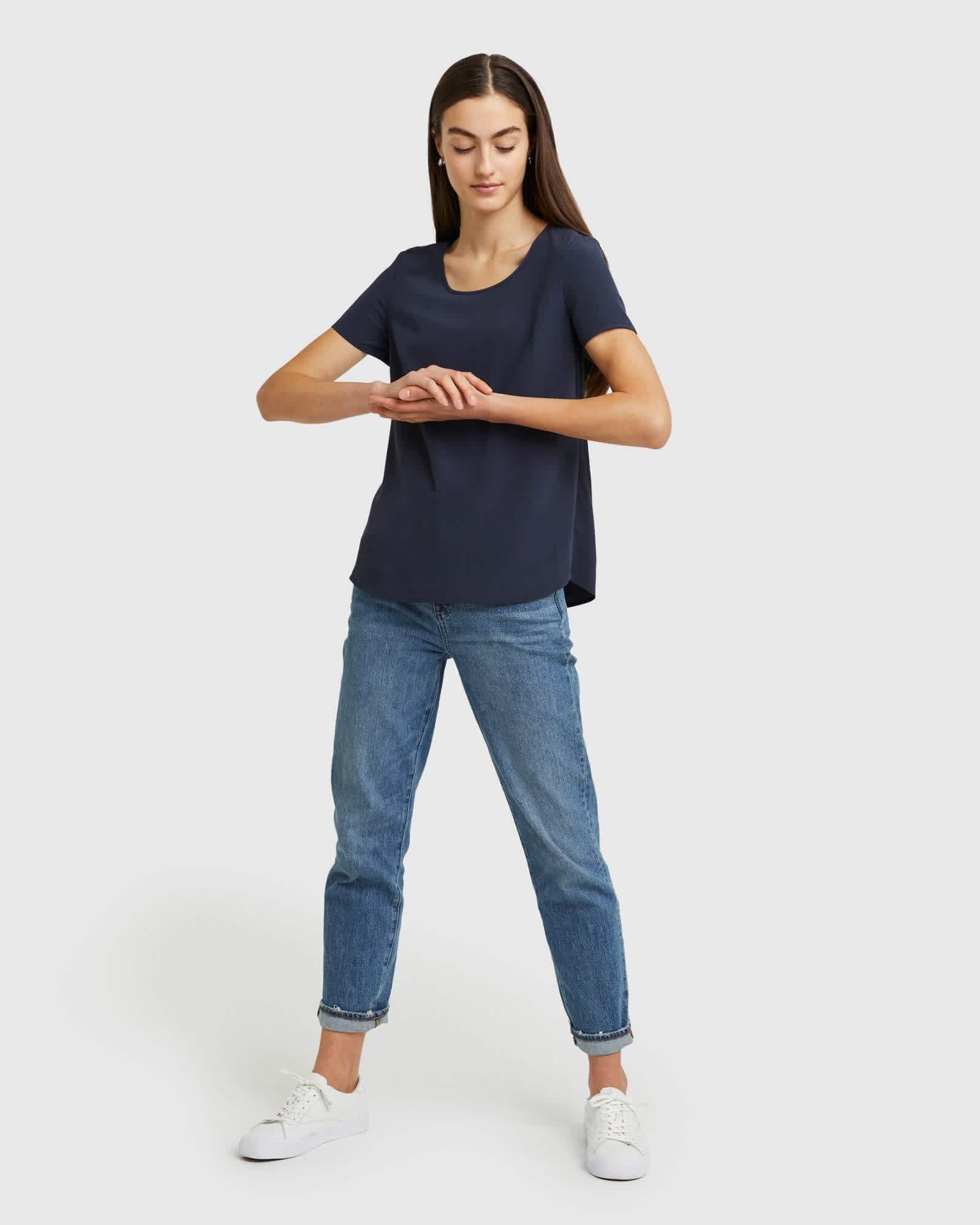 Woman wearing silk tee in navy from front standing