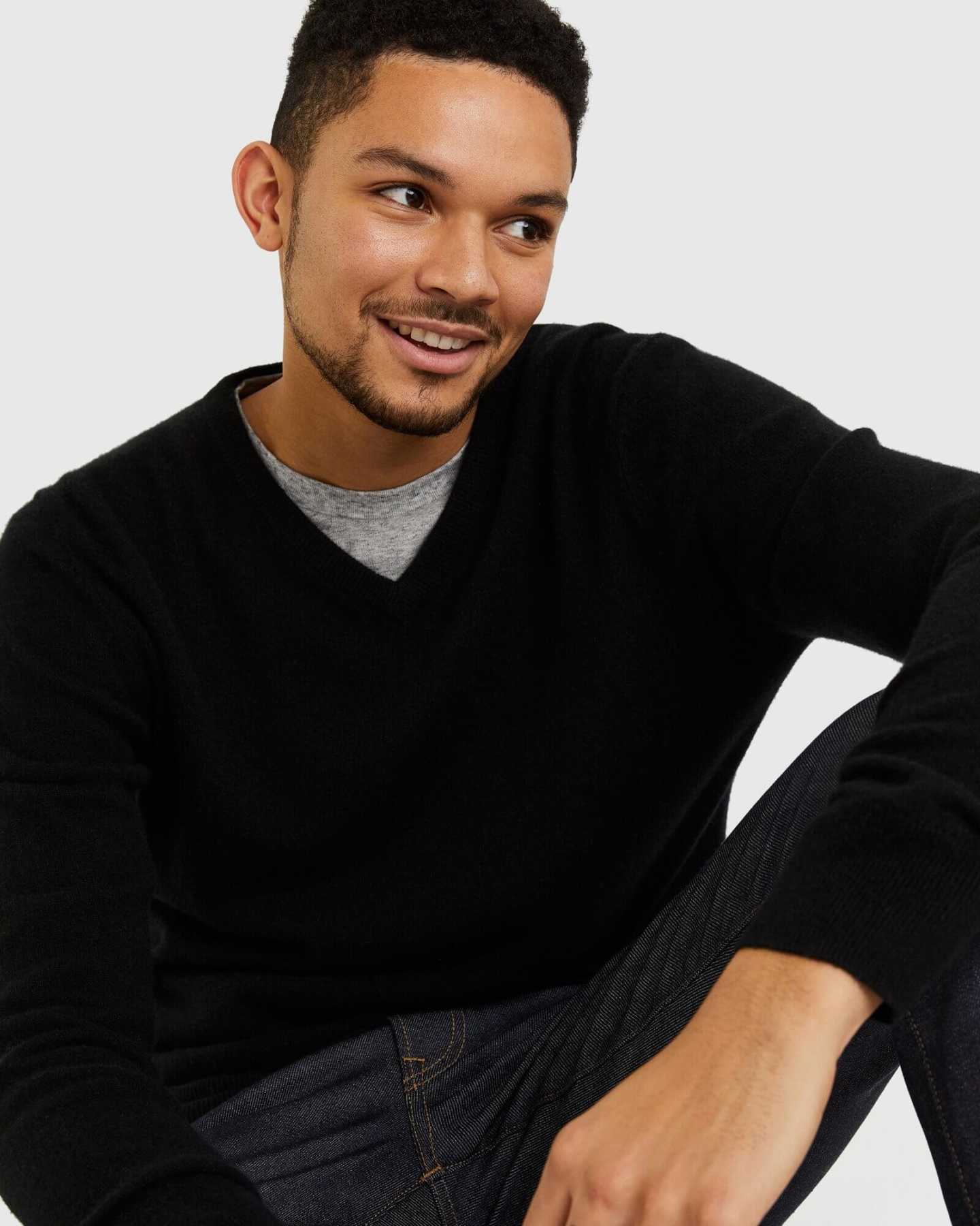 Man wearing black cashmere v-neck sweater for men looking to side