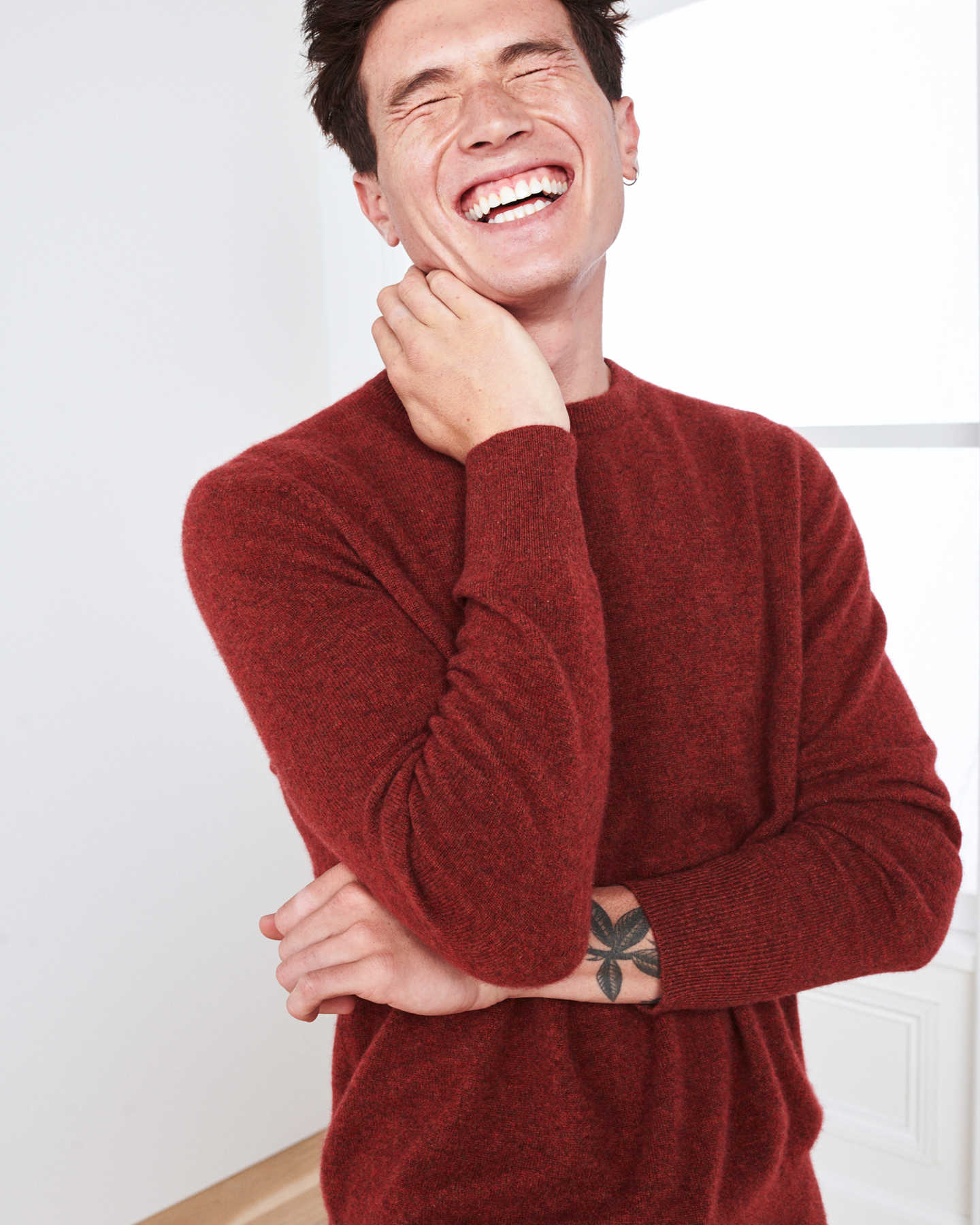 Man wearing red men's cashmere sweater laughing